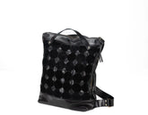 Black quilted backpack on a white background