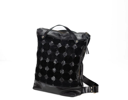 Black quilted backpack on a white background
