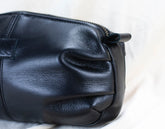 Black leather handbag on a light background