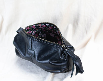 Black leather clutch with floral interior on a white background