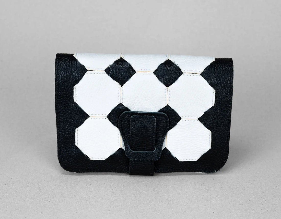 Black and white geometric patterned clutch bag on a gray background