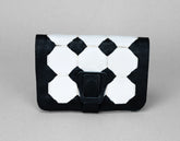 Black and white geometric patterned clutch bag on a gray background