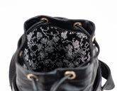 Black leather bag with floral patterned interior on a white background
