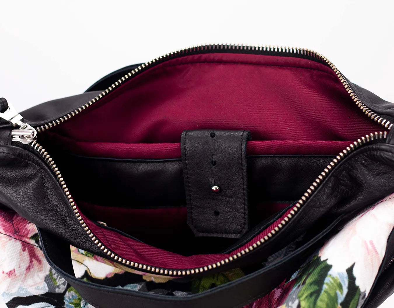 Close-up of a black leather bag with a floral patterned lining.