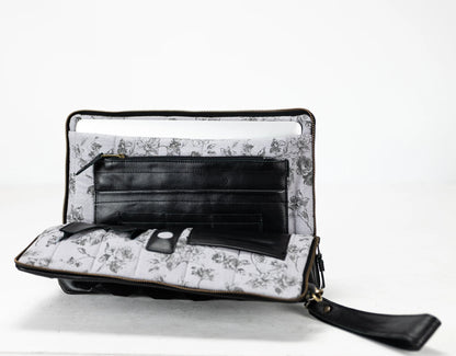 Floral-patterned clutch bag with a black interior on a white background