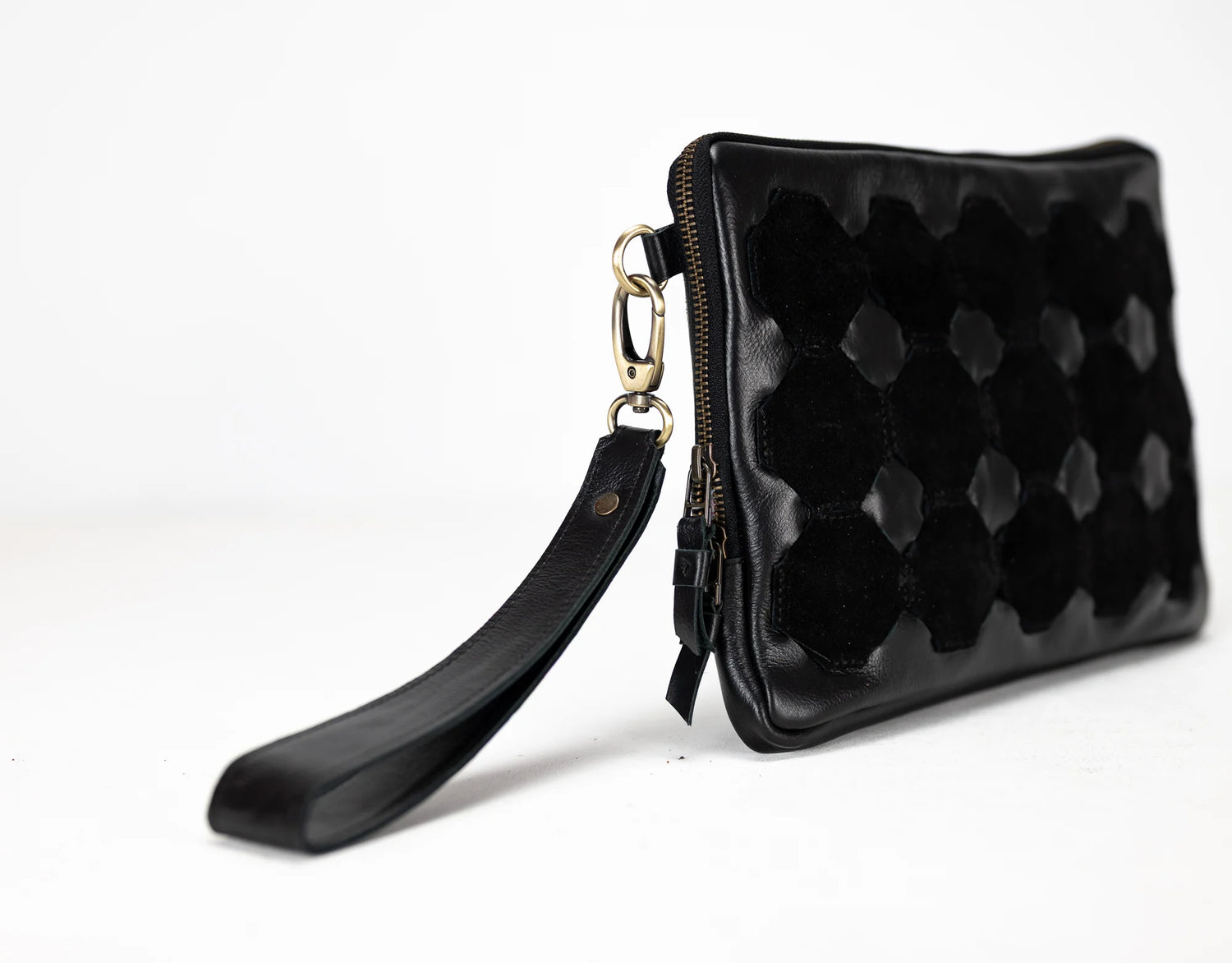 Black quilted clutch bag with a strap on a white background