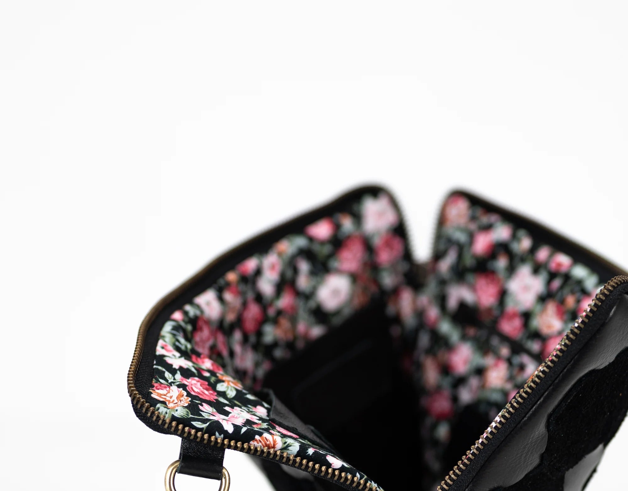 Floral-patterned clutch bag with a black interior on a white background