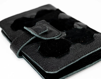 Black leather wallet with a buckle detail on a white background