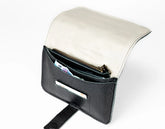 Black leather clutch with gold zipper on a white background