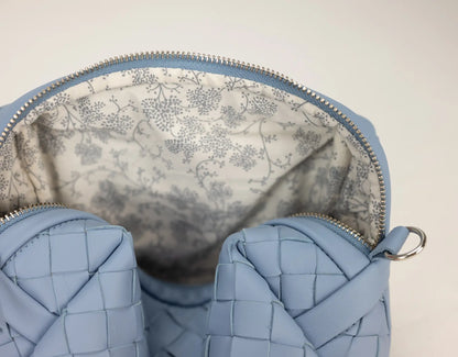 Close-up of a blue woven handbag with floral lining
