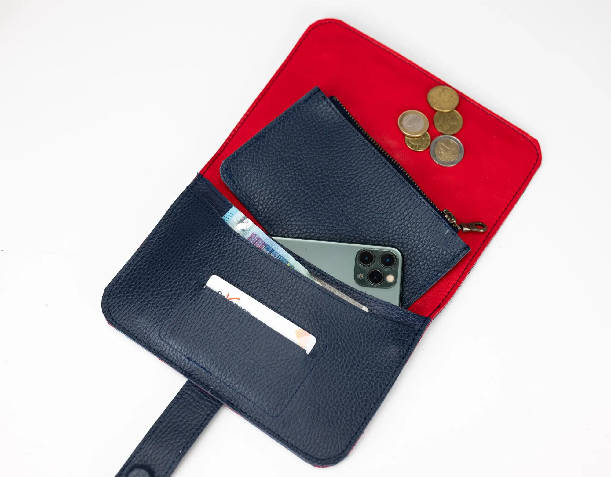 Black wallet with phone and coins on a red pouch