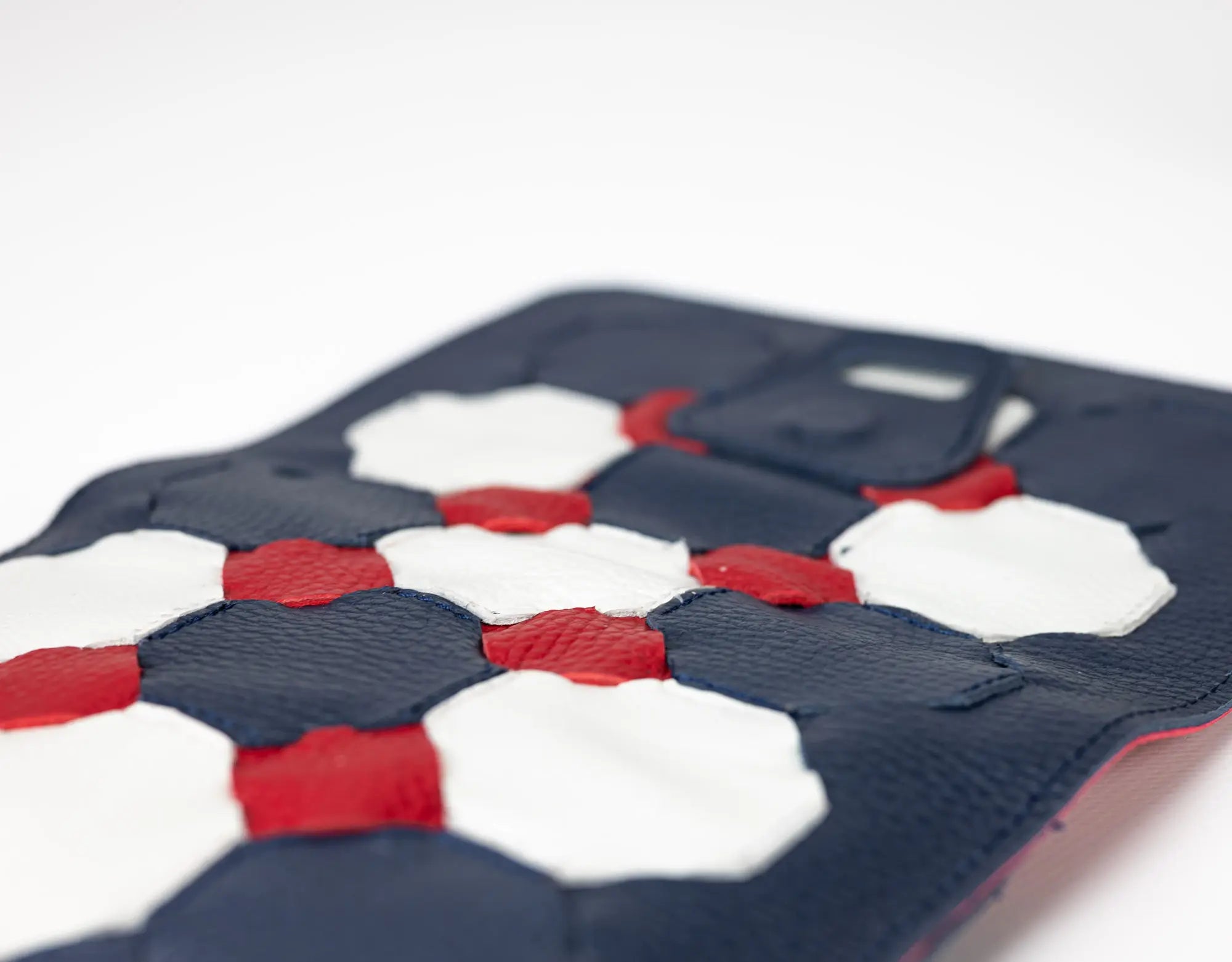 Phone case with geometric pattern in navy, red, and white on a white background