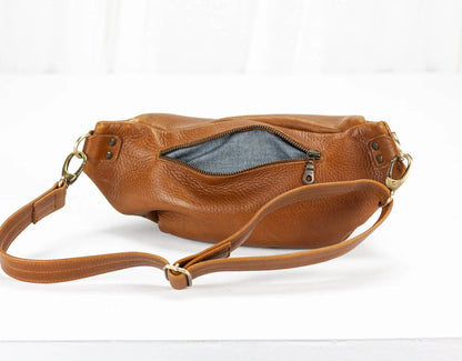 Brown leather handbag with a visible zipper on a white background