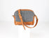 Handbag with houndstooth pattern and brown leather accents on a white background