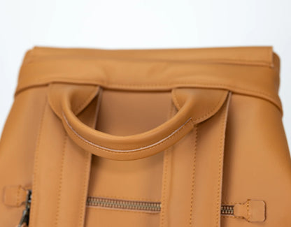 Close-up of a tan leather bag with handles on a white background