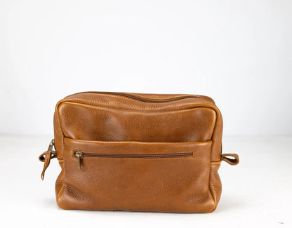 Brown leather bag with a zipper on a white background