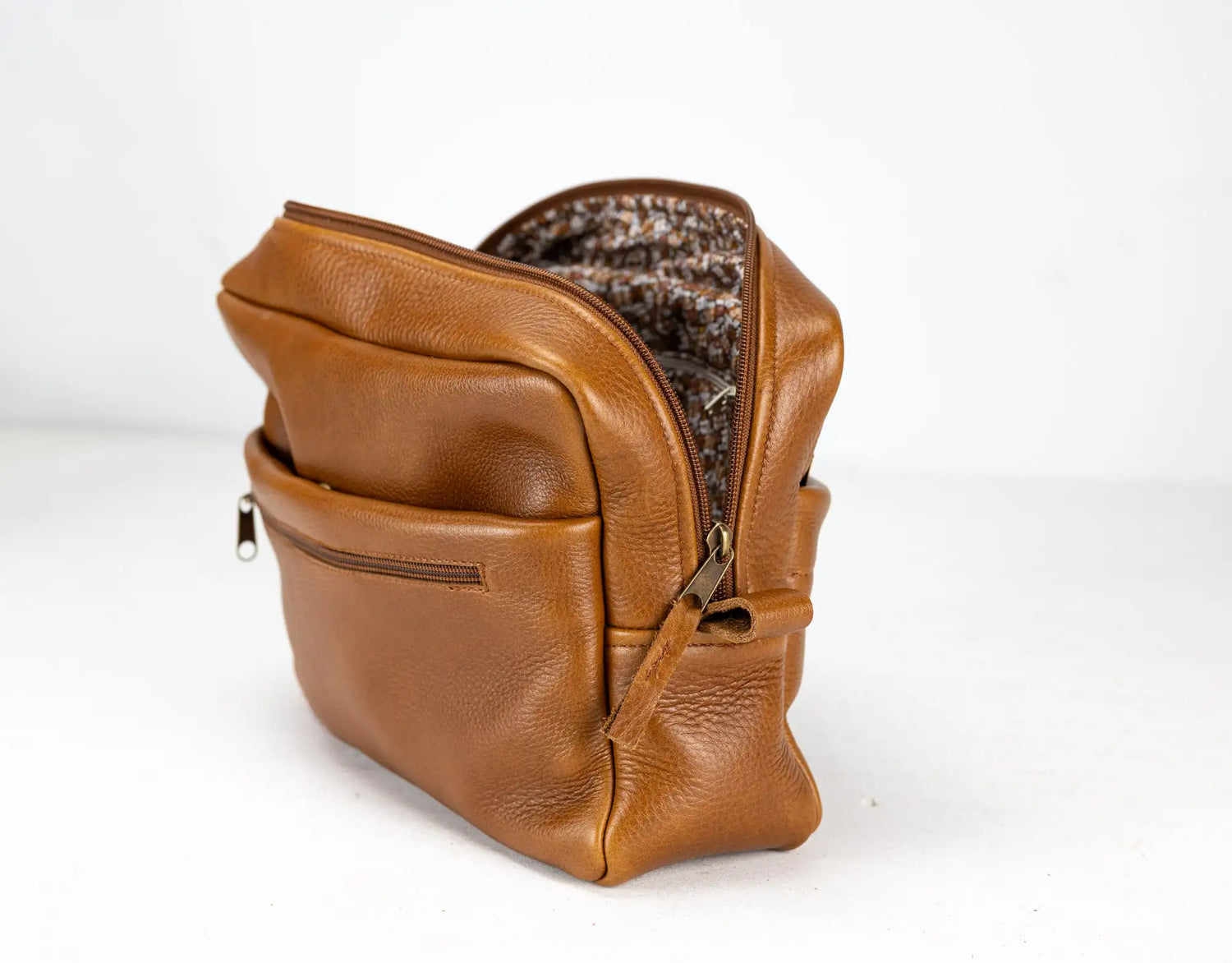 Brown leather bag with a textured interior on a white background