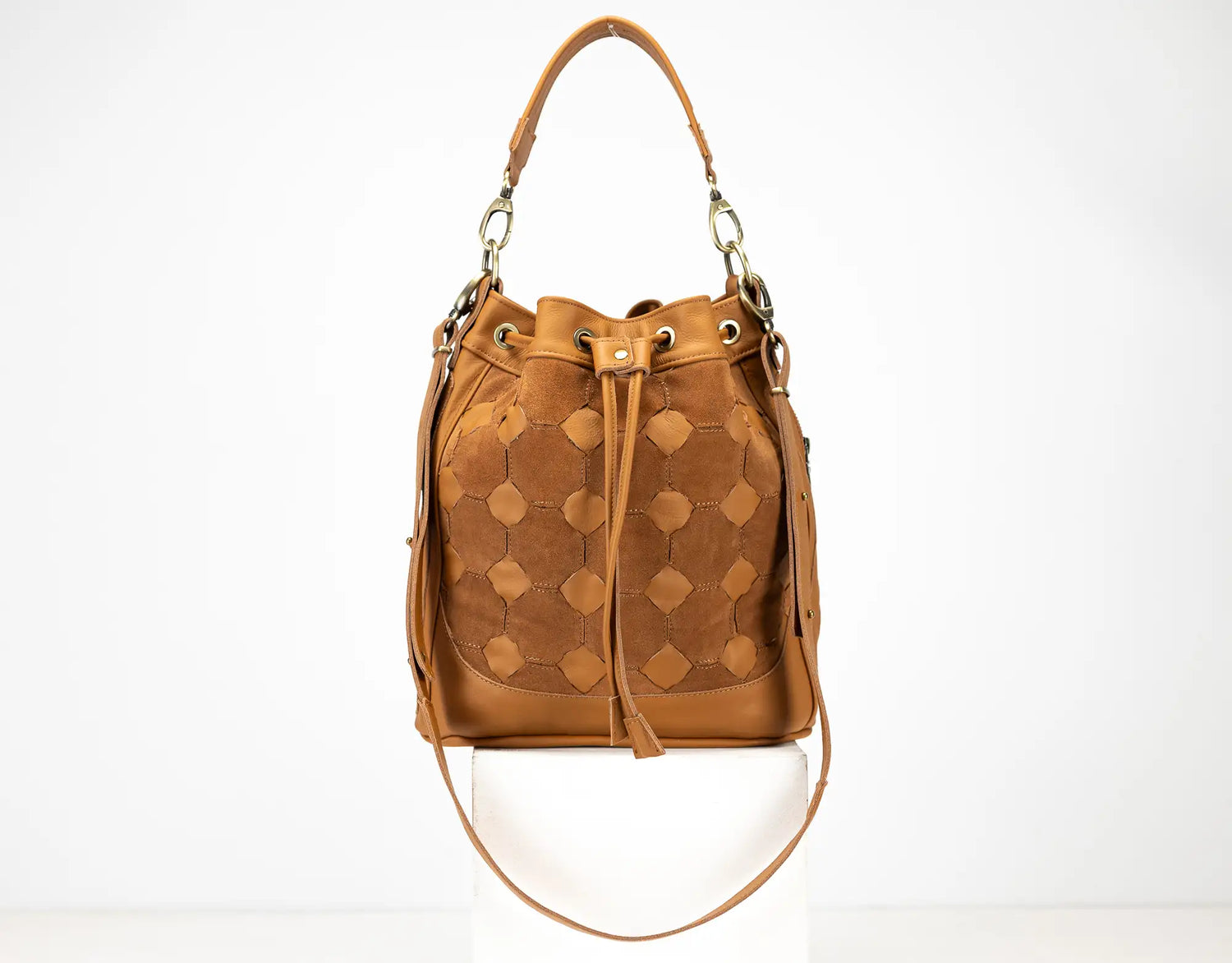 Brown leather bucket bag with geometric pattern on a white background