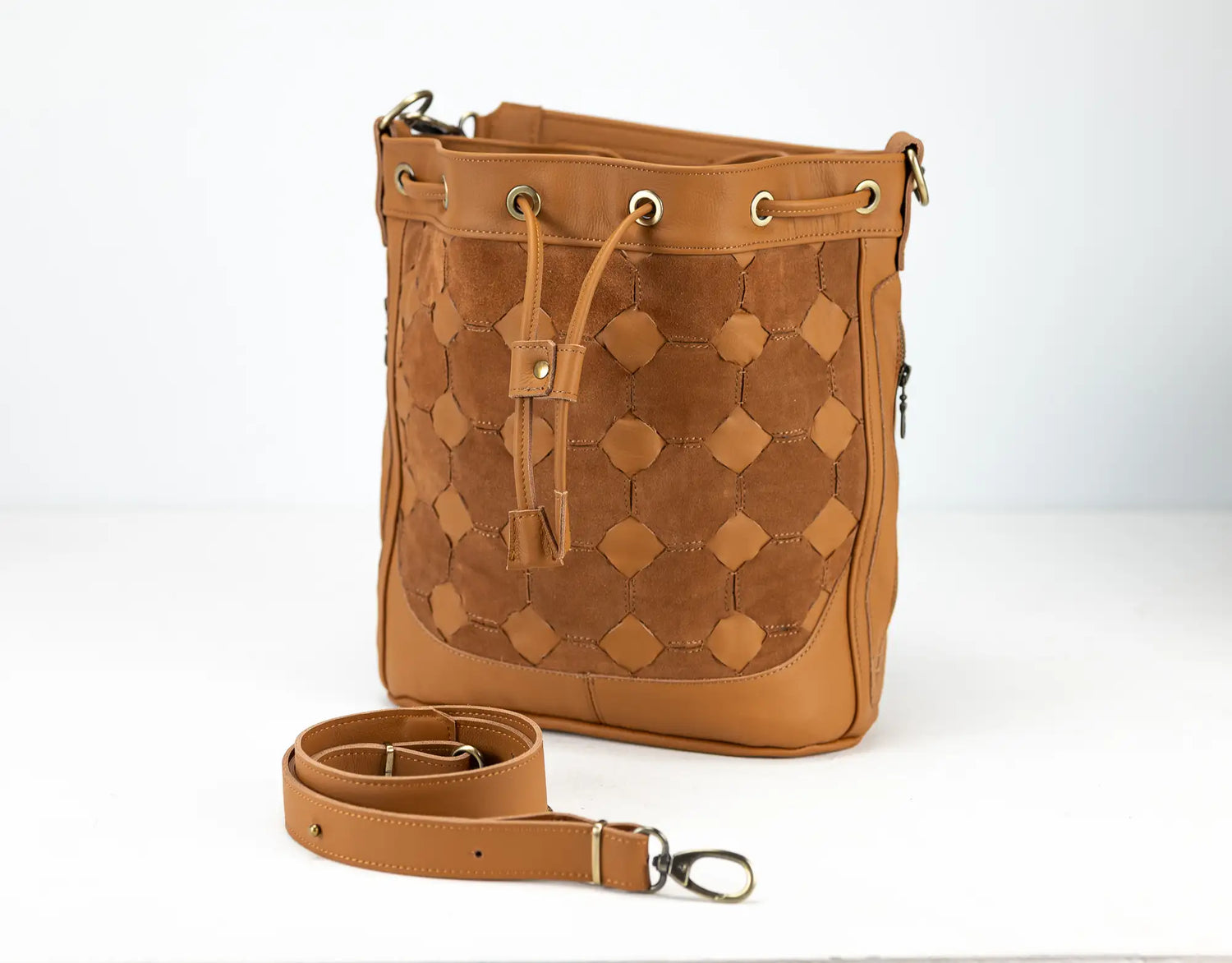 Brown leather handbag with geometric pattern on a white background