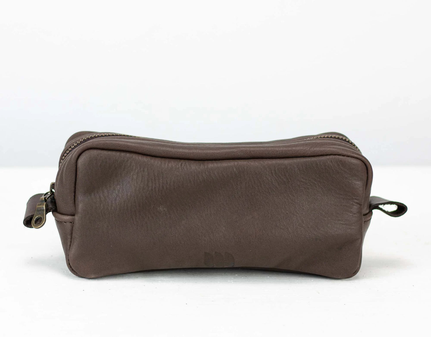 Brown leather toiletry bag on a white background