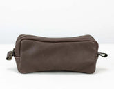 Brown leather toiletry bag on a white background