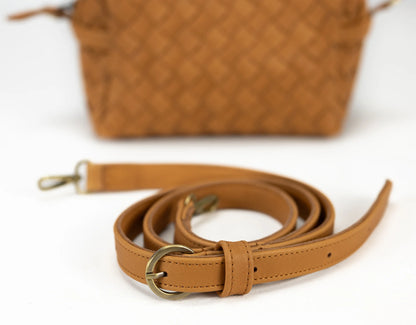 Brown leather strap with gold buckle on a white background