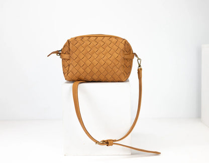 Brown woven handbag with a strap on a white background