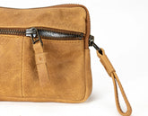 Brown leather clutch bag with a strap on a white background