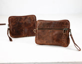 Two brown leather clutch bags on a white background