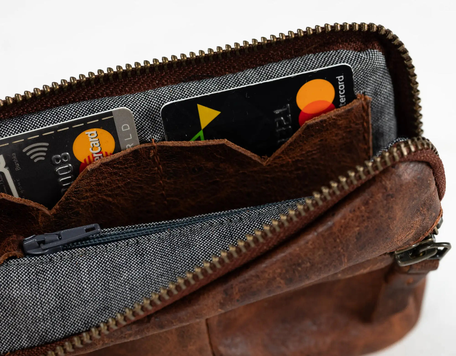 Brown leather wallet with credit cards inside on a white background