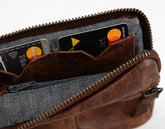 Brown leather wallet with credit cards inside on a white background