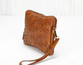 Brown woven leather crossbody bag on a white background