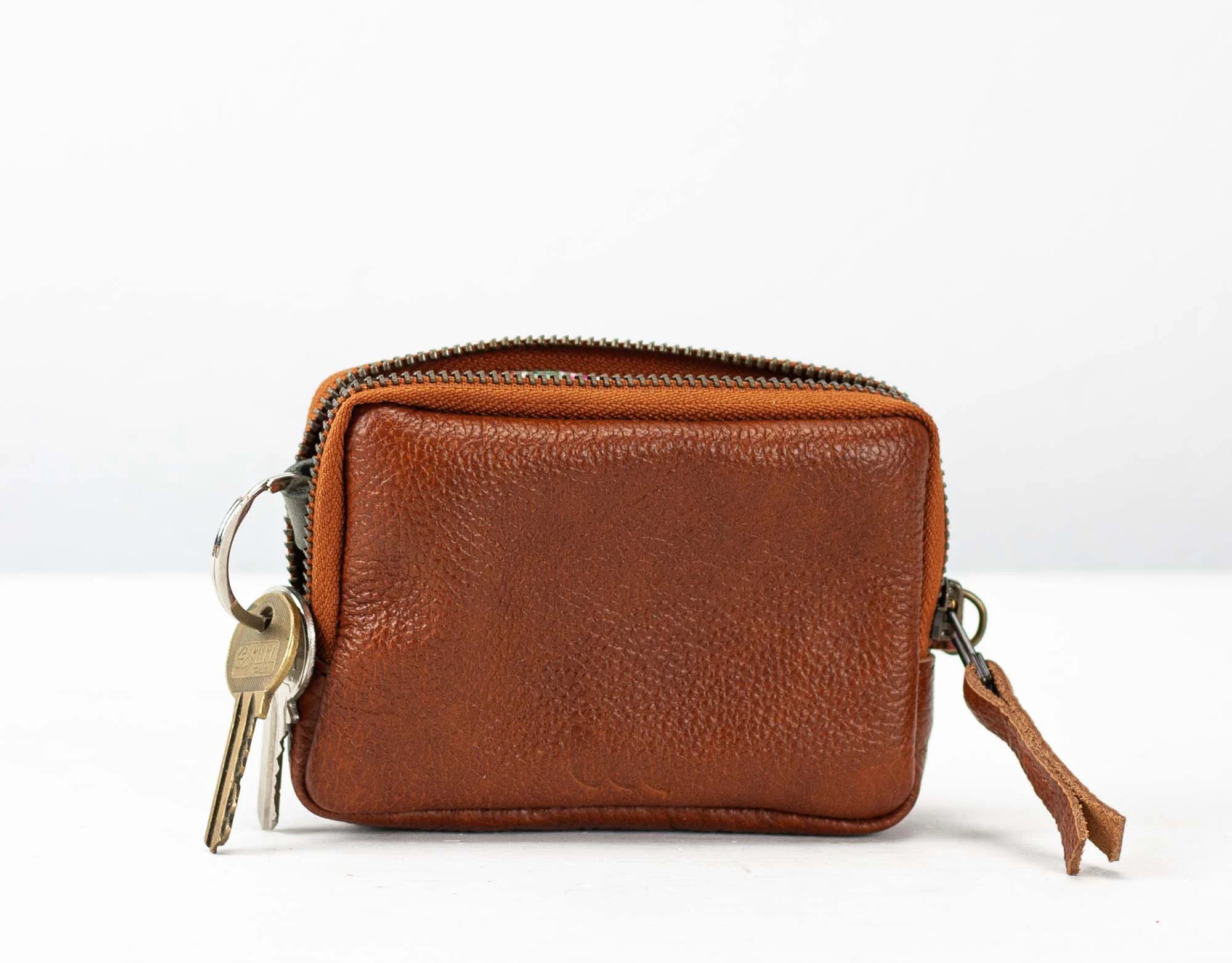 Brown leather wallet with a key attached on a white background