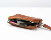 Brown leather pouch with floral lining on a white background