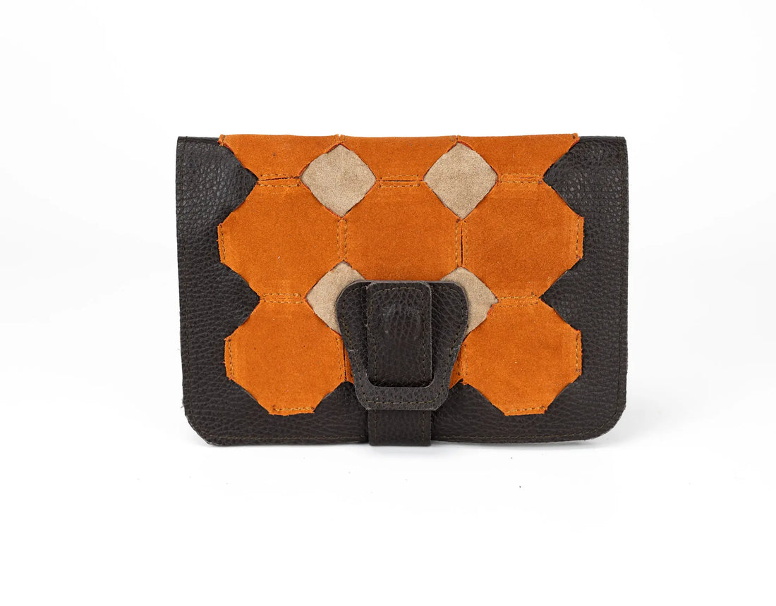 Brown leather wallet with orange geometric pattern and black strap on a white background