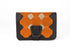 Brown leather wallet with orange geometric pattern and black strap on a white background