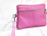 Pink leather crossbody bag on a marble surface