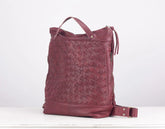 Maroon woven leather bag on a white background