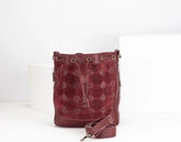 Red textured handbag with a strap on a white background