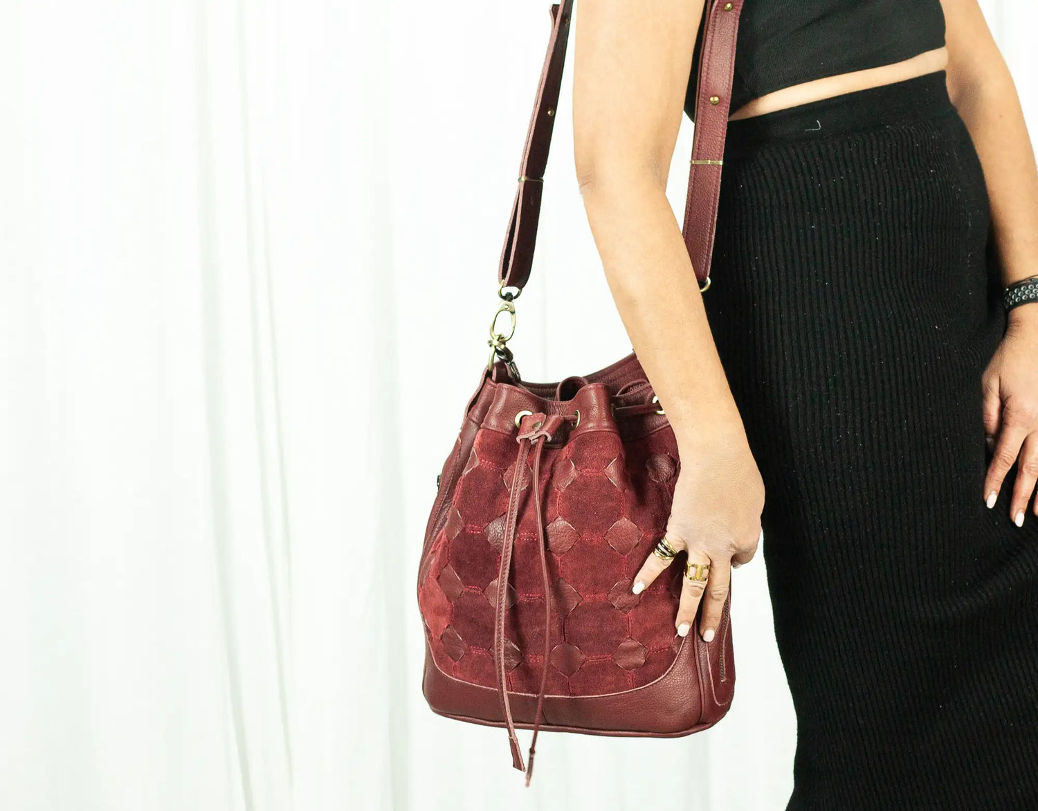 Person holding a red leather handbag against a white background