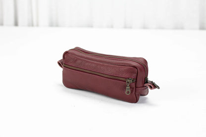 Maroon leather pouch with zipper on a white background