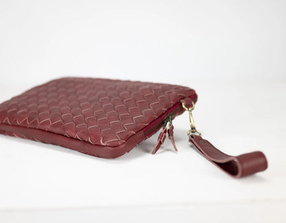 Maroon woven leather clutch bag on a white background