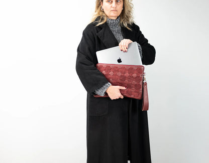 Maroon woven leather clutch bag on a white background