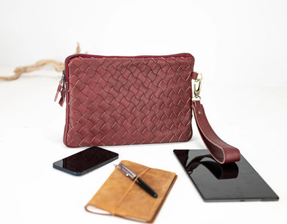 Red woven handbag with a phone, notebook, and tablet on a white background