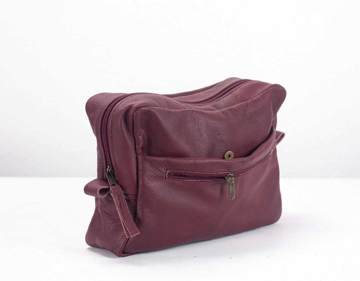 Maroon leather bag on a white background