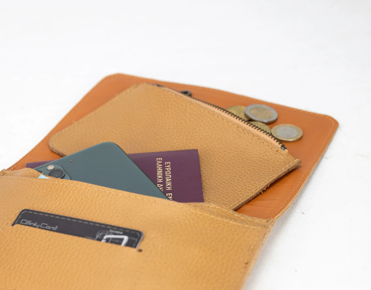 Brown leather wallet with coins and cards on a white background
