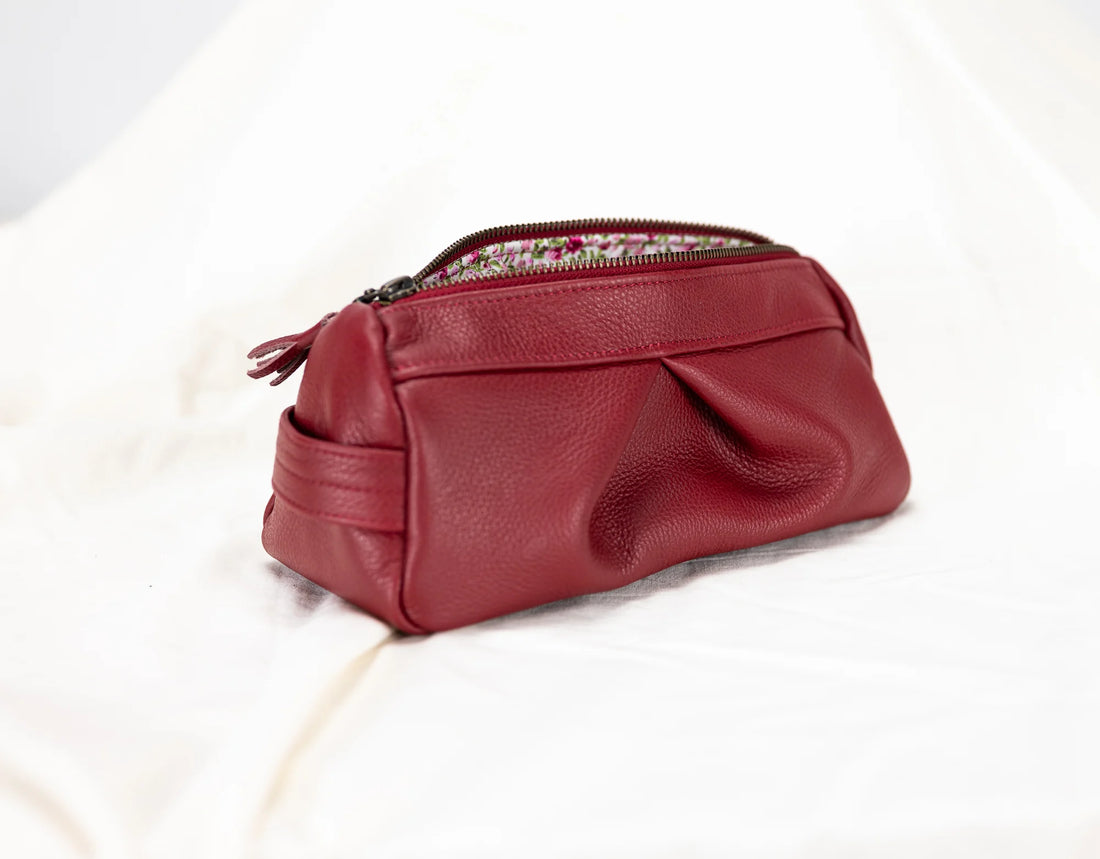 Red leather pouch with a zipper on a white background