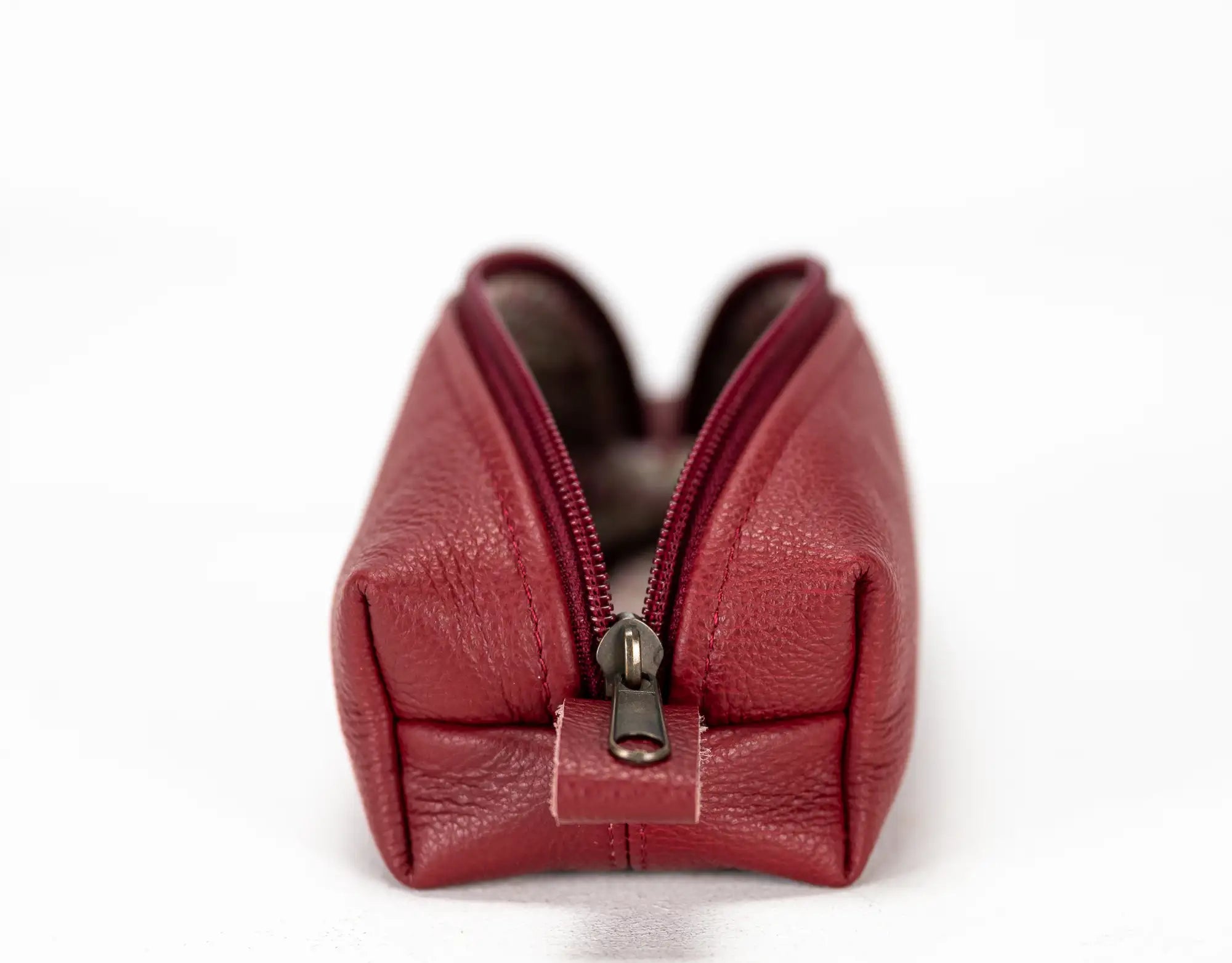 Red leather pouch with a zipper on a white background