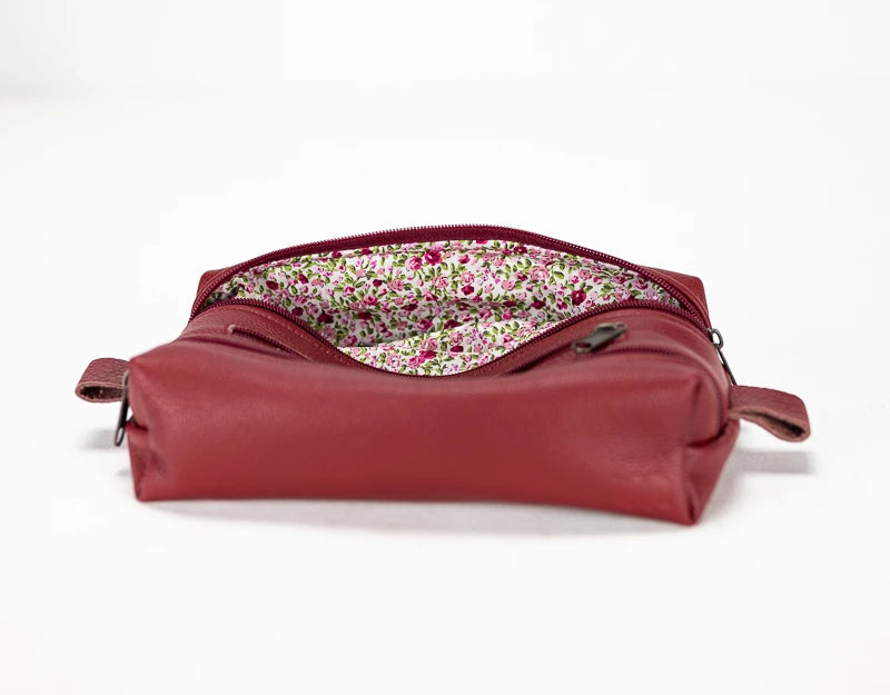 Red leather bag with floral lining on a white background#color_deep-red
