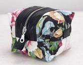 Floral patterned toiletry bag with black accents on a light background
